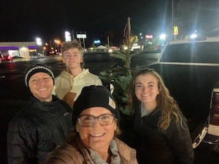 Cindy and her family in front of a lit up background