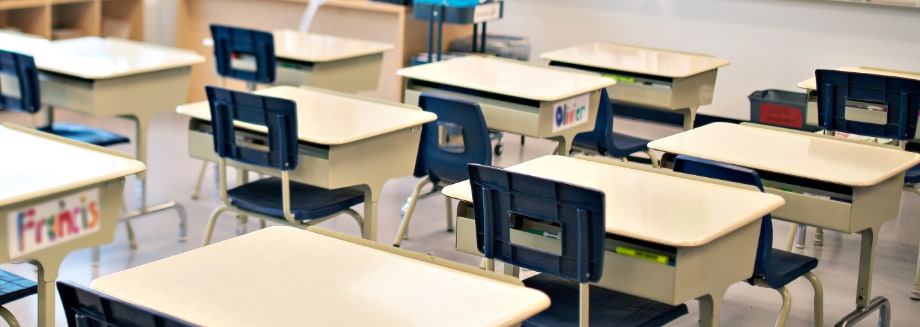 A photo of empty desks in an elementary school classroom